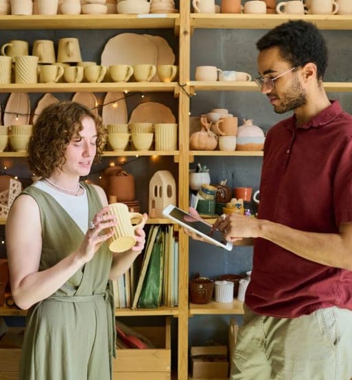 Deux personnes verifiant une piece de poterie dans un atelier